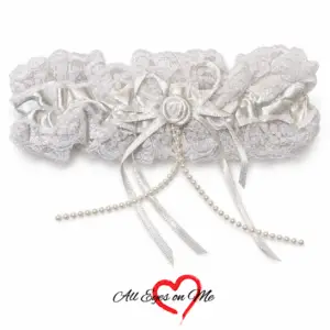 White garter with lace trim, ribbon bow and pearl-like bead strands, front view