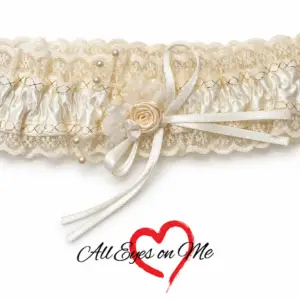 Off-white lace garter with satin rose, pearl accents, ribbon loops and gold-trimmed band