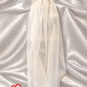 Off-white tulle veil with white feather trim