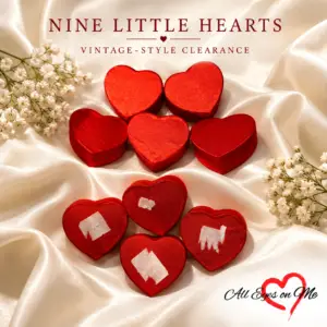 Nine red heart-shaped vintage-style wedding favour boxes on ivory satin