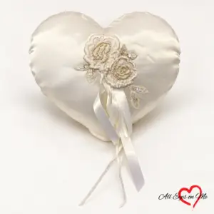 Off-white heart-shaped ring cushion with beaded floral lace, sequinned leaves and satin ribbons.