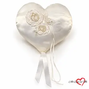 Off-white heart-shaped satin ring cushion with two beaded lace flowers, sequinned leaves and hanging ribbons.