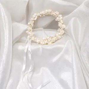 White and ivory handmade fabric rose flower crown with decorative leaves and long white ribbon ties